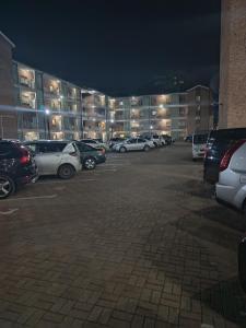 a parking lot with cars parked in front of a building at EcoCity Lodge in Harare