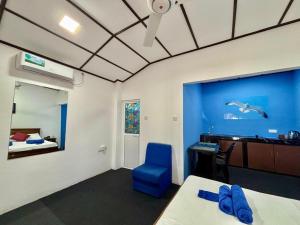 een kamer met een bed, een bureau en een blauwe stoel bij Sea Breeze Stay in Negombo