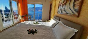 een slaapkamer met een bed met uitzicht op de oceaan bij Appartamenti Villa Eden in Malcesine