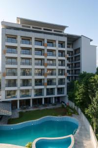 ein Mehrfamilienhaus mit einem Swimmingpool davor in der Unterkunft Soaltee Westend Lakeside Pokhara in Pokhara