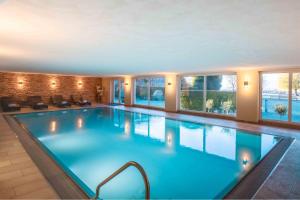 een groot zwembad in een hotel met ramen bij Hotel Lipprandt in Wasserburg