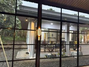 a glass window of a house with a table at Sehaliah Agricultural Farm Resort in Amadeo
