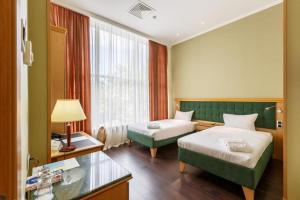 una camera d'albergo con due letti e una finestra di Shera Park Boutique Hotel a Almaty