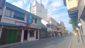eine leere Stadtstraße mit vielen Geschäften und Gebäuden in der Unterkunft Hotel Suite Americano in Pereira