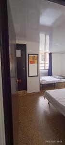 Zimmer mit 2 Betten und einer Tür mit Fenster in der Unterkunft Hotel Suite Americano in Pereira + 4 Fotos