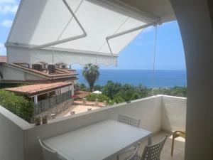 een balkon met een tafel en uitzicht op de oceaan bij La Bouganville in Sapri
