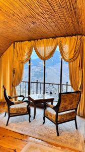 ein Wohnzimmer mit zwei Stühlen und einem Tisch in der Unterkunft İsgobya Chalets 103 in Macka