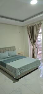 a bedroom with a large bed with a window at SAMBATH SAKSETH Guesthouse in Phumĭ Nésat
