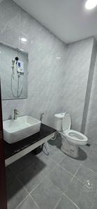 a bathroom with a toilet and a sink at SAMBATH SAKSETH Guesthouse in Phumĭ Nésat