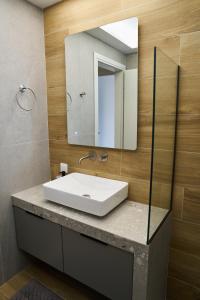 un bagno con un lavandino bianco e uno specchio di ANESIS Luxury Apartments a Komotini Altre 24 foto