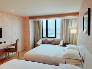a hotel room with two beds and a desk at Wemeet Hotel in Pingtung City +68 photos