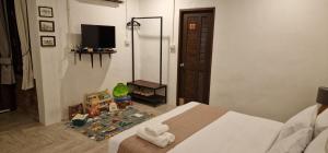 a bedroom with a bed and a tv in a room at Kingfisher House in Sangkhla Buri