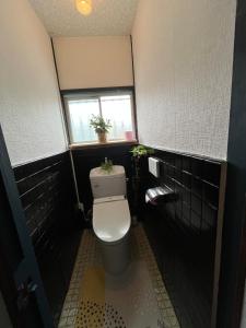 ein Badezimmer mit einem WC mit zwei Pflanzen darauf in der Unterkunft Entire house for rent in Beppu with a dog run in Beppu + 12 Fotos