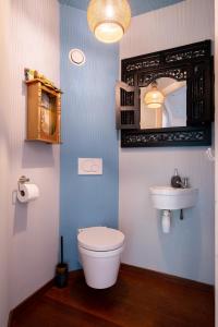 een badkamer met een wit toilet en een wastafel bij LOFT Groepsaccommodatie in Boxum