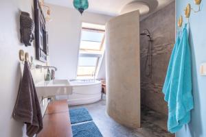 een badkamer met een wastafel en een bad bij LOFT Groepsaccommodatie in Boxum +89 foto's