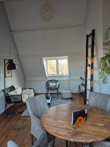 een woonkamer met een houten tafel en stoelen bij Divino in Dordrecht