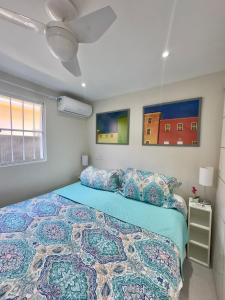 a bedroom with a bed with a blue comforter at Cozy House in Pipa