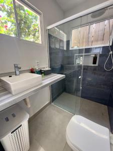 a bathroom with a shower and a sink and a toilet at Cozy House in Pipa