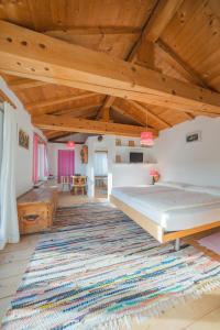 een grote slaapkamer met een bed en een tapijt bij Hotel Haus am Waldrand in Flims +23 foto's