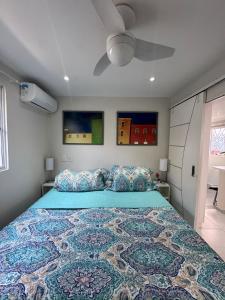 a bedroom with a large bed with a blue bedspread at Cozy House in Pipa