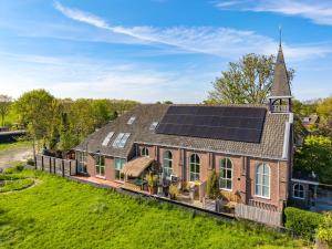 an old brick church with solar panels on the roof at LOFT Groepsaccommodatie in Boksum