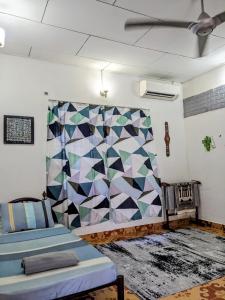 a room with two beds and a quilt on the wall at Djalai Roomstay in Kepala Batas