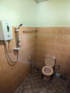 a bathroom with a toilet and a shower at Djalai Roomstay in Kepala Batas