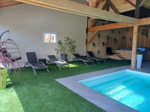 a patio with chairs and a swimming pool in a yard at Gîtes Kymsourit - Sauna - SPA - proche Europa-Park et Rulantica - Centre Alsace in Sand
