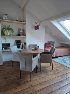 een eetkamer met een tafel en stoelen en een bed bij Divino in Dordrecht