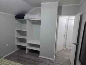 a room with a closet with white shelves and a door at Villa Parque Cordillera 1 in Chillán +10 photos