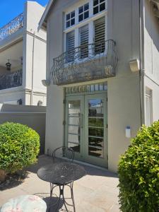 a table and chair in front of a building at Cherry Tree House, Newlands in Cape Town