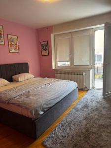 een slaapkamer met een bed en een roze muur bij Ferhadija Old Town Apartments in Sarajevo