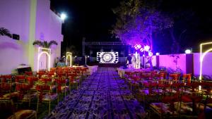 a banquet hall with tables and chairs and purple lights at Hotel Ranavilas Palace in Jaipur +86 photos