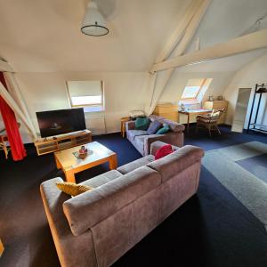 ein Wohnzimmer mit zwei Sofas und einem Flachbildfernseher in der Unterkunft Apartment Campinor in Neerpelt