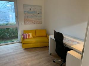 ein Wohnzimmer mit einer gelben Couch und einem Schreibtisch in der Unterkunft Casada: 3-Zimmer-Zuhause mit Büro in Wismar