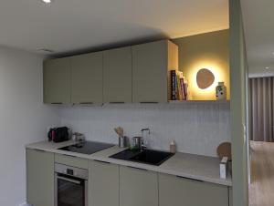 eine Küche mit weißen Schränken und einer Spüle in der Unterkunft Logement Indépendant - à proximité de Lille in Lambersart