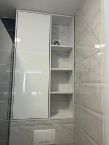 a white cabinet with a mirror in a bathroom at Studio Vučko in Pale