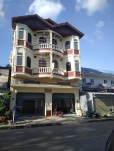 een groot gebouw met een balkon aan de straatkant bij Orlardee hostel in Thakhek