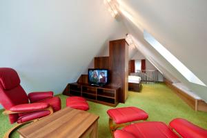 een woonkamer met rode stoelen en een televisie bij Parkvilla Appartements in Bad Hofgastein +5 foto's