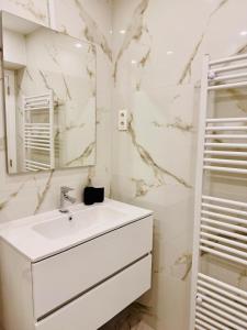 a white bathroom with a sink and a mirror at Skyline Duplex Brussels Parking Fibre Modernité in Brussels