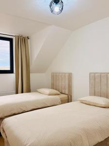 due letti uno accanto all'altro in una stanza di Skyline Duplex Brussels Parking Fibre Modernité a Bruxelles