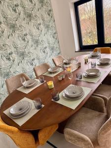 a wooden table with plates and dishes on it at Skyline Duplex Brussels Parking Fibre Modernité in Brussels +26 photos