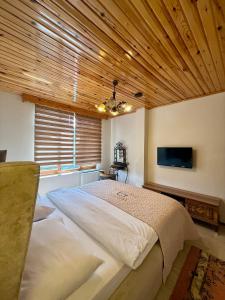 a bedroom with a large bed and a flat screen tv at Isgobya Sumela Monastery 102 in Macka