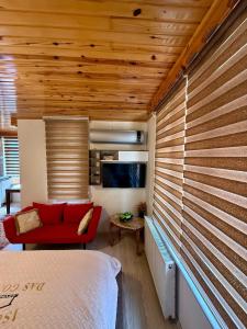 a room with a bed and a red couch and a tv at Isgobya Sumela Monastery 102 in Macka