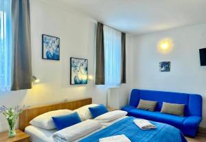 a bedroom with a blue bed and a blue couch at Hotel Keltika in Izola