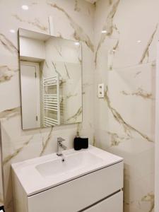 un bagno bianco con lavandino e specchio di Skyline Duplex Brussels Parking Fibre Modernité a Bruxelles