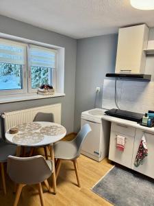 a small kitchen with a table and chairs and a counter at Apartament Za Potokiem in Groń