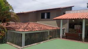 a house with a tile roof and a fence at Recanto do alberto in Camacari