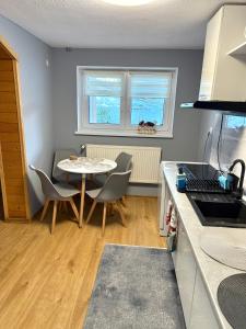 a kitchen with a table and chairs and a table and a table at Apartament Za Potokiem in Groń