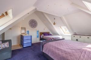 a attic bedroom with two beds and a chair at LOFT Groepsaccommodatie in Boksum